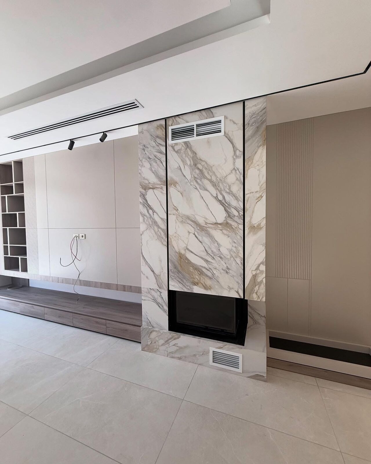 A ceiling diffuser above a marble fireplace feature wall in a finished villa.