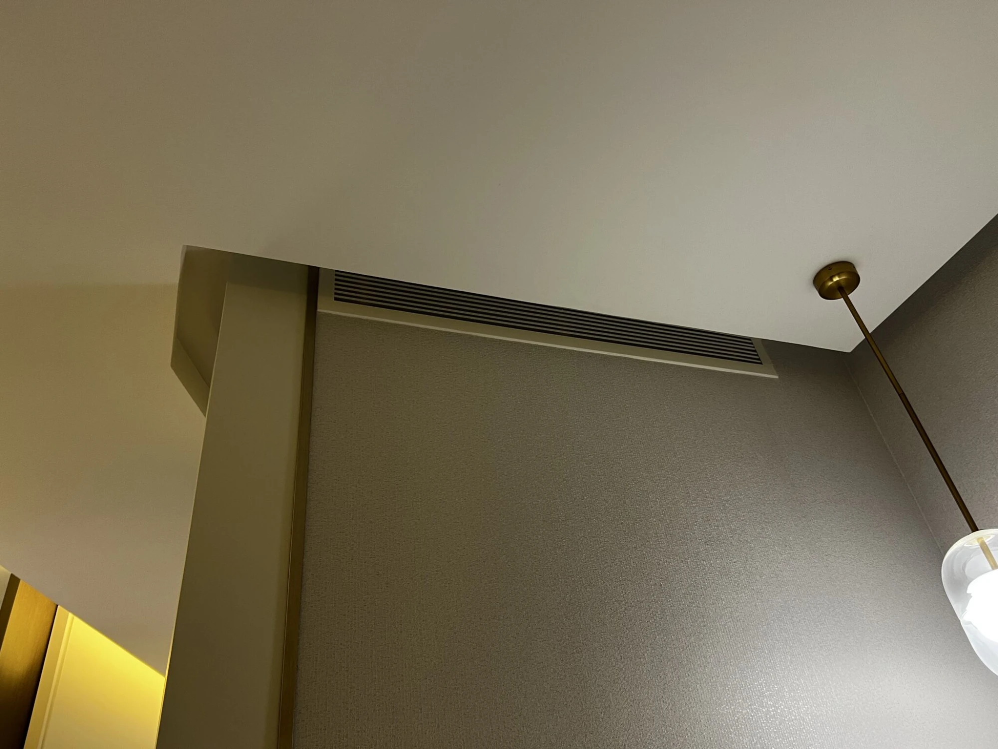 A return grille tucked into the bulkhead above the wall panel.